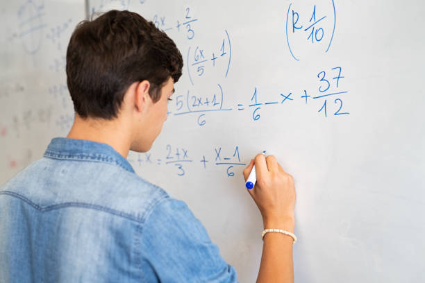 Student working through a mathematics problem on a whiteboard